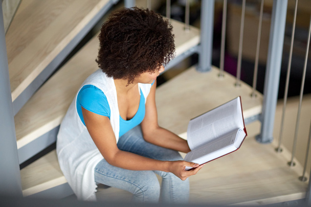африканська студентка читає книгу в бібліотеці
 - Фото, зображення