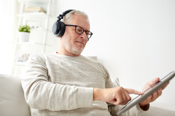 senior man with tablet pc and headphones at home - Foto, immagini
