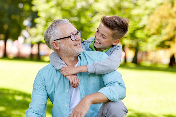 grandfather and grandson hugging at summer park - Фото, зображення