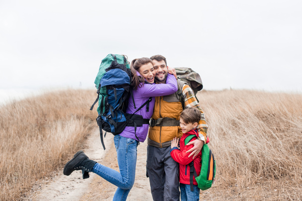 Familia feliz con mochilas abrazando
  - Foto, Imagen