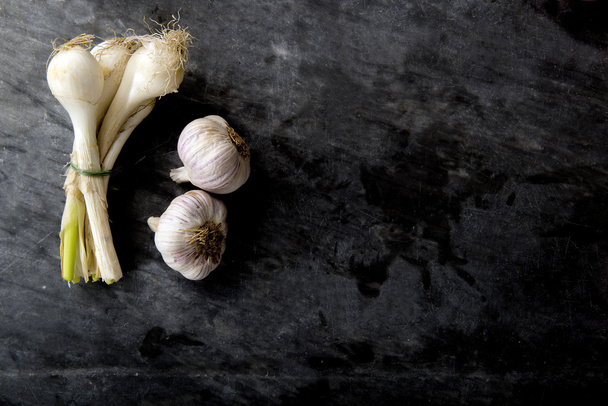 onion and garlic on black marble - 写真・画像
