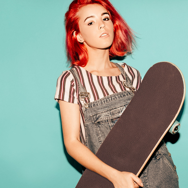 Pretty teenager girl with red hair and skateboard Urban style - Fotoğraf, Görsel