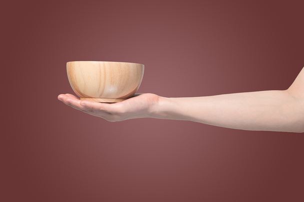 hand holding wooden plate  on isolated gradient red background - Foto, Imagen