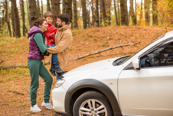 Famille heureuse près de la voiture en forêt
 - Photo, image