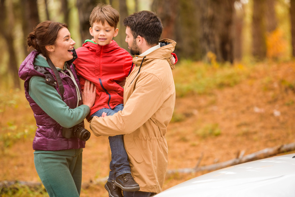 Happy family near car in forest - 写真・画像