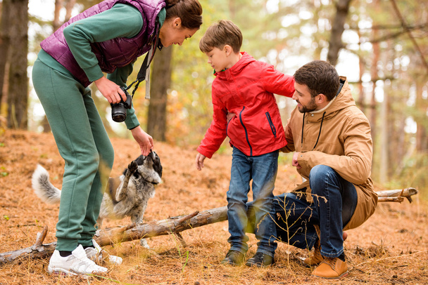 Happy family with dog in forest - Foto, afbeelding