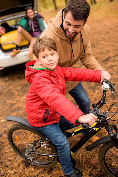 Father teaching son to ride bicycle - Foto, Bild