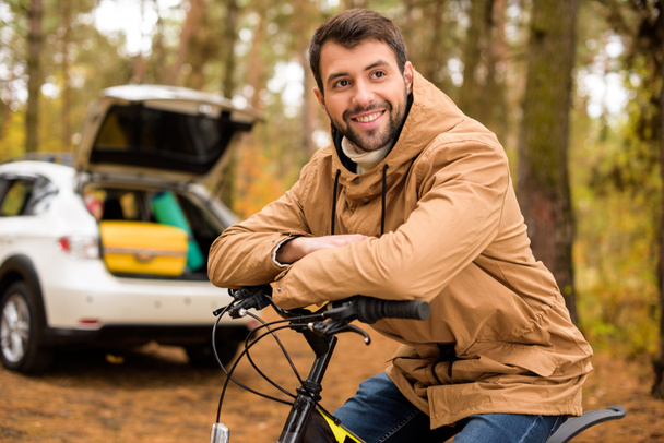 Smiling man sitting on bicycle  - Foto, Imagem