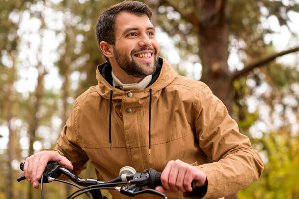 Smiling man sitting on bicycle  - Foto, Bild