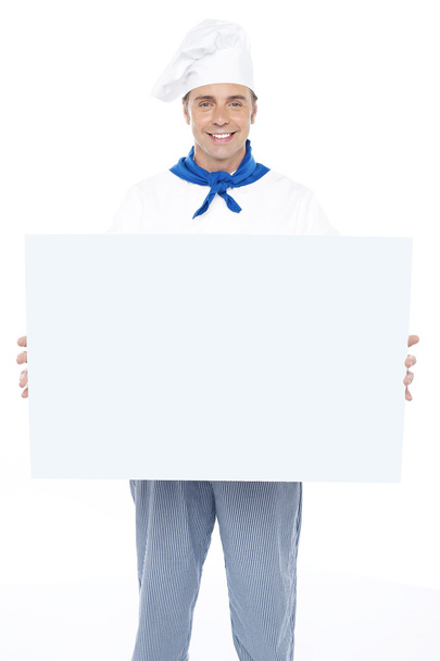 Handsome male chef holding ad board - Photo, image