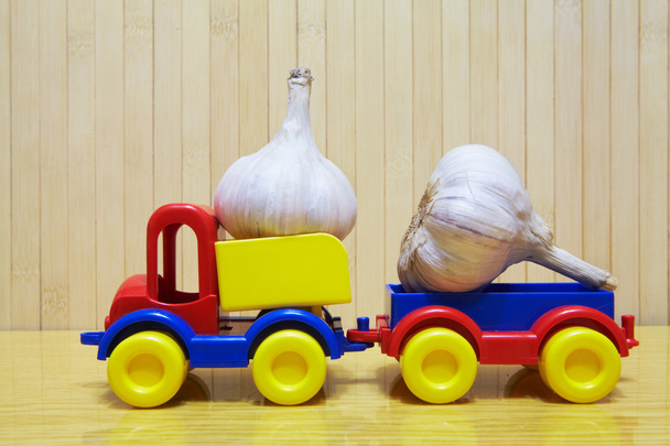Toy plastic car with garlic - Φωτογραφία, εικόνα