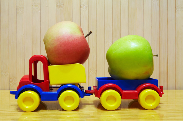 Toy plastic car with apple - Foto, afbeelding