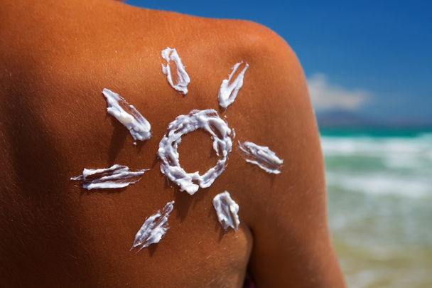 a sun of the cream on the female back on the beach - Photo, Image