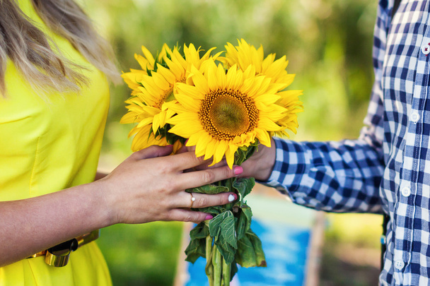 young man gives a bouquet of sunflowers - Photo, Image