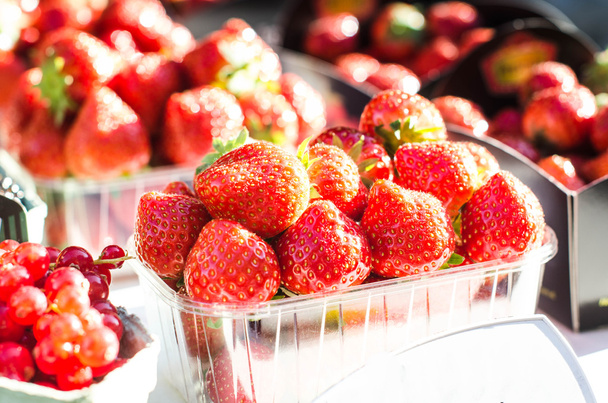 Strawberry on a white tablecloth. Fruits market. Shop on a street. Agricultural and harvesting  - Foto, Imagem