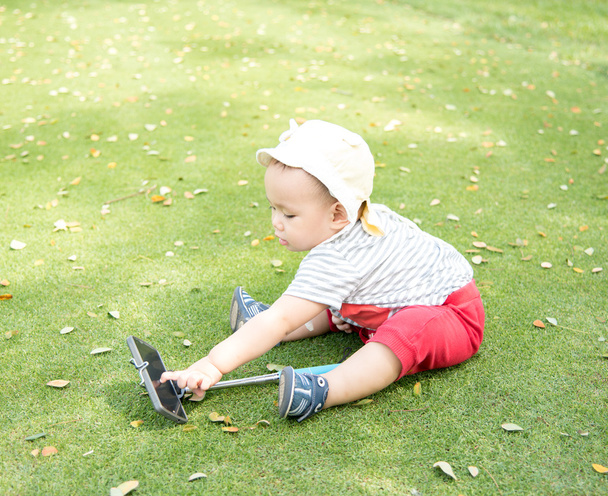 Asian baby taking selfie photo on the green grass field in the p - Photo, Image