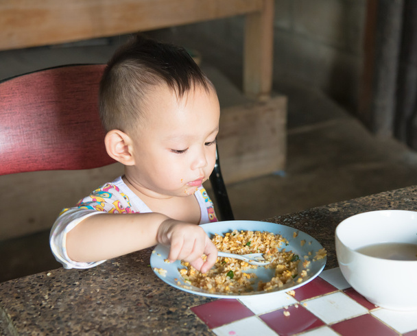 Bambino tailandese che mangia riso fritto da solo
 - Foto, immagini