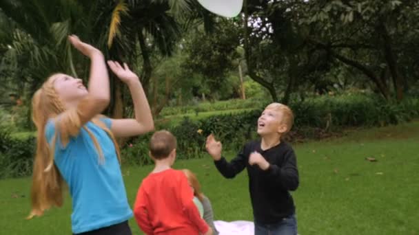 A family starts a simple game of hitting balloons in the air - slowmo - Séquence, vidéo