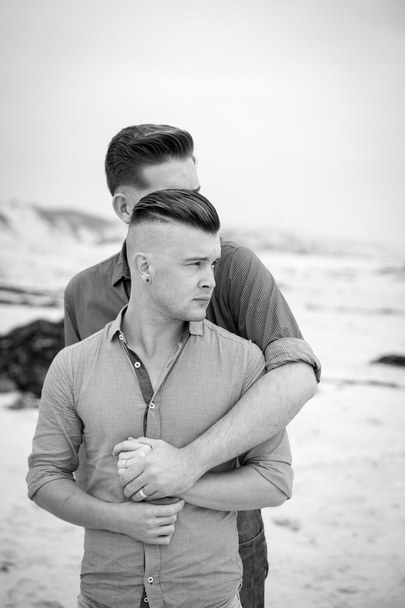 Γκέι άντρες αγκαλιάζει σε μια παραλία - Φωτογραφία, εικόνα