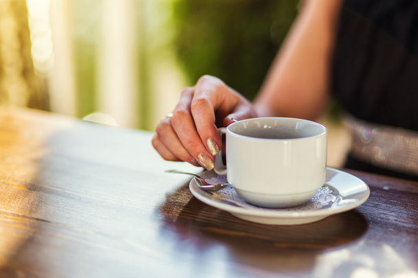 bir fincan kahve tutan genç kız - Fotoğraf, Görsel