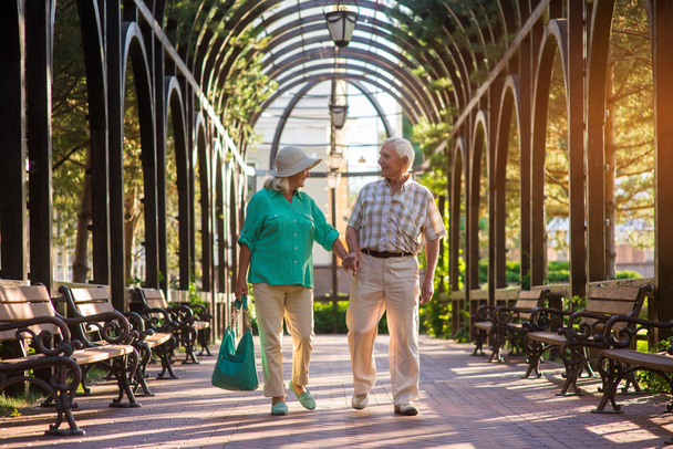 Senior couple walking along alley. - Photo, Image