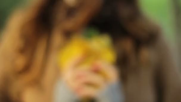 дівчина тримає в руках букет жовтого листя і грає з ним
 - Кадри, відео