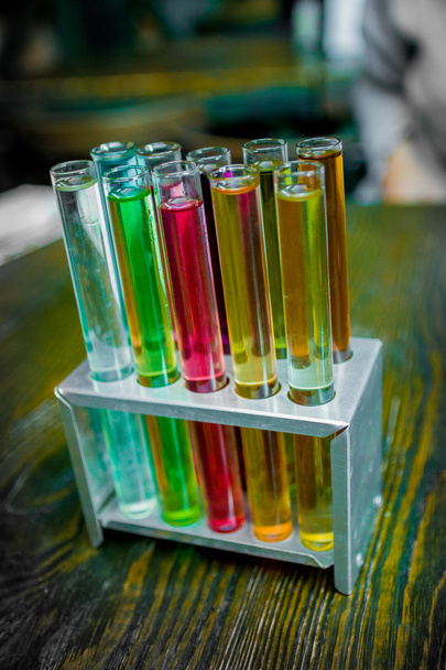 Test tubes in workbench in chemical laboratory on wooden background. Close up.  - Foto, afbeelding