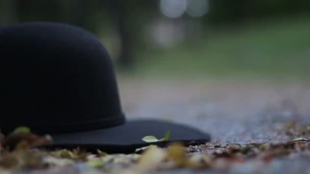 Μαύρο μοντέρνο καπέλο πέφτει το έδαφος-προς τα πίσω  - Πλάνα, βίντεο