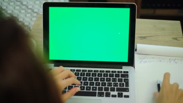жінка друкує на ноутбуці з ключовим зеленим екраном
. - Кадри, відео