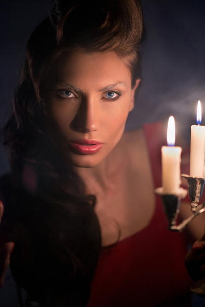 Woman looking on red candles in the fabulous night - Foto, Imagem