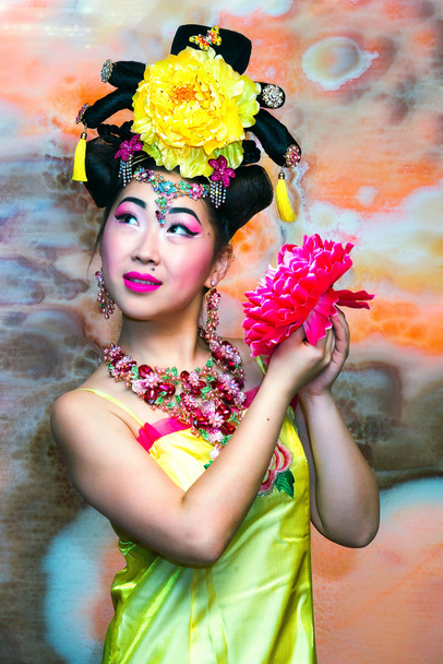 Retrato da menina bonita chinesa no vestido chinês tradicional amarelo com flor
 - Foto, Imagem