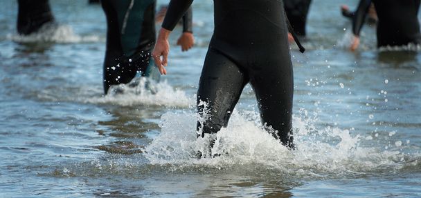 Тріатлоністи біжать у морі
 - Фото, зображення