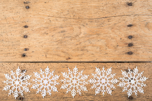 snowflakes against a rustic wooden surface - Φωτογραφία, εικόνα
