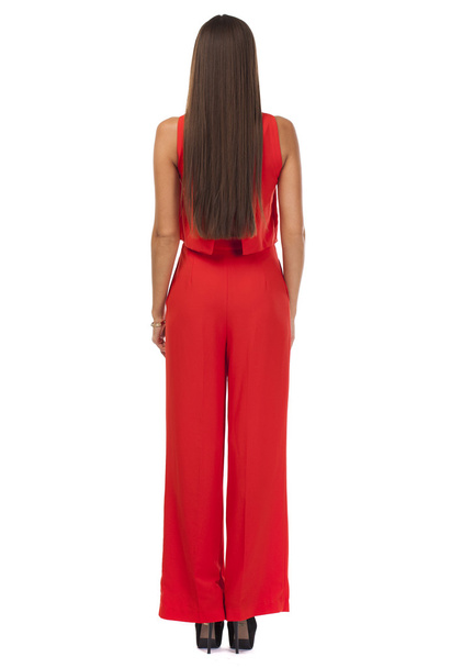 Back view. Young brunette woman in red pantsuit - Photo, Image