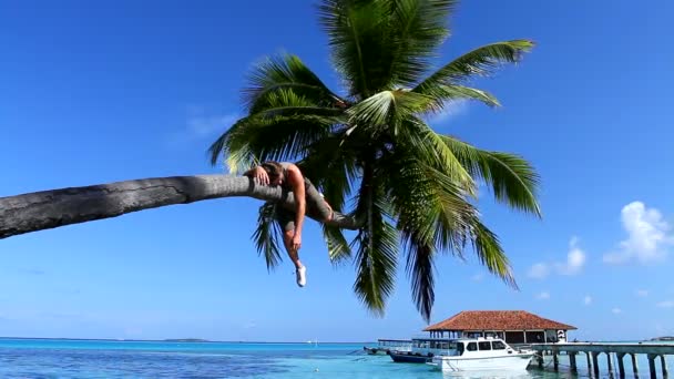 Handsome man is sleeping on a palm tree - Footage, Video