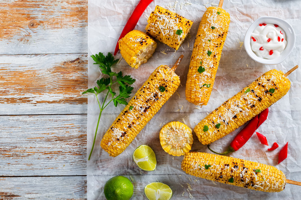 Tasty Grilled corn on cob sprinkled with parsley and parmesan - Фото, зображення