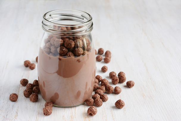 Chocolate milk with chocolate cereal balls in a glass jar  - Foto, imagen