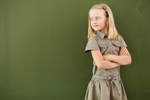 Scoolgirl standing near blackboard - Foto, afbeelding