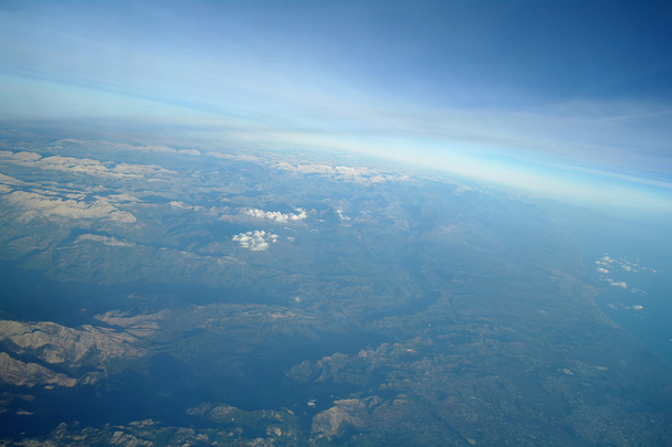 Vista aérea sobre las nubes y el paisaje
 - Foto, Imagen