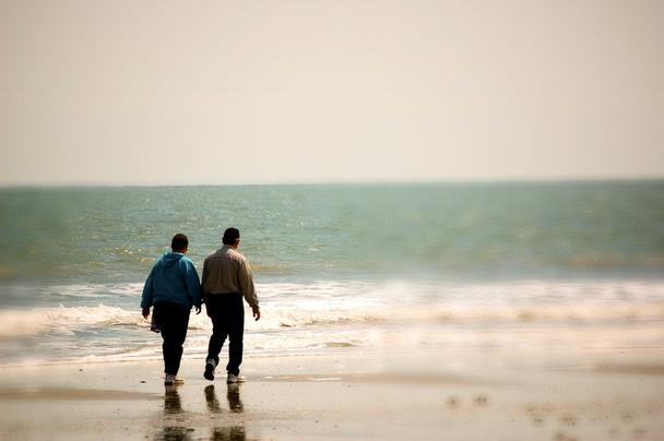 ouder koppel wandelen op het strand - Foto, afbeelding