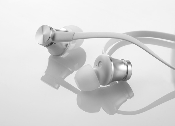 Auscultadores Fones de ouvido em fundo branco reflexivo
 - Foto, Imagem