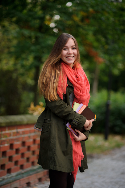 Charming student in a beautiful autumn park. - Foto, Imagen