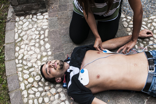 Menina chamando o serviço de emergência para um homem inconsciente
 - Foto, Imagem