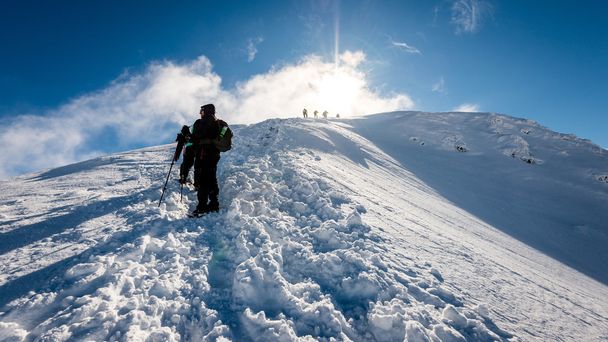 turisty těší vysoké hory ve sněhu za slunečného dne - Fotografie, Obrázek