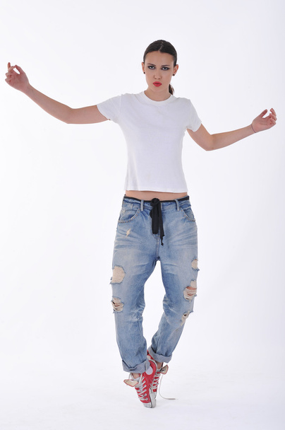 junges Mädchen posiert in blauer Jeanshose und weißem Dirndl im Studio - Foto, Bild