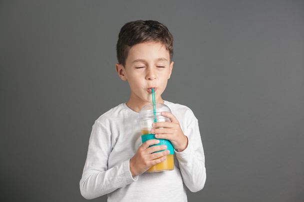 Menino engraçado bebendo um suco de cola fresco através de uma palha
 - Foto, Imagem