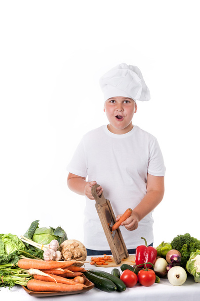 Un niño pequeño como cocinero haciendo ensalada, cocinando con verduras
 - Foto, imagen