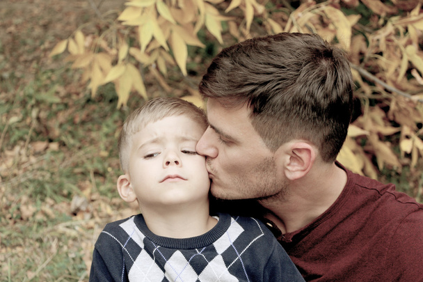 Vater hält seinen Sohn in den Armen, Kuss auf die Wange - Foto, Bild