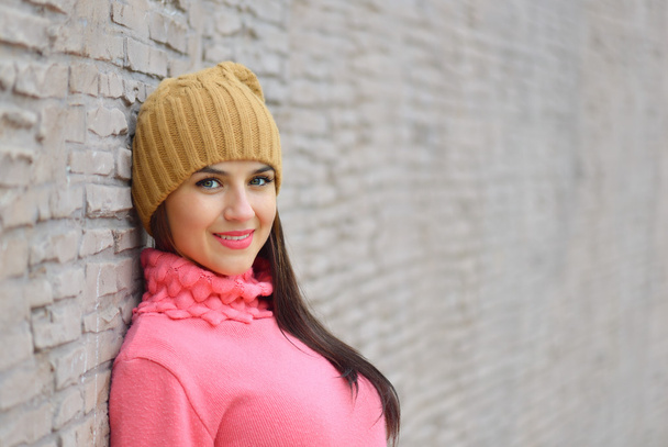 Retrato de moda chica cool en ropa de colores sobre fondo de madera con un sombrero y suéter rosa
 - Foto, imagen