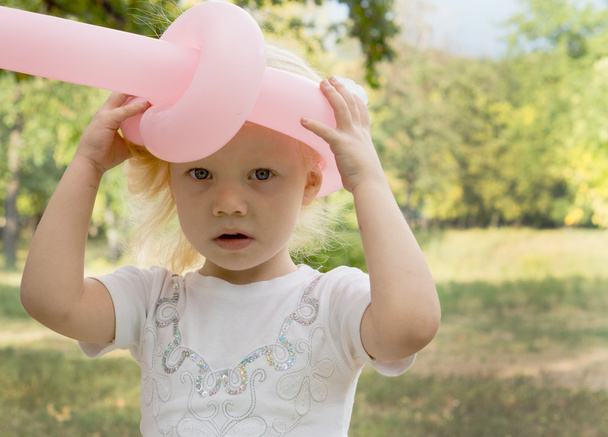 Little girl wearing a balloon hat - 写真・画像